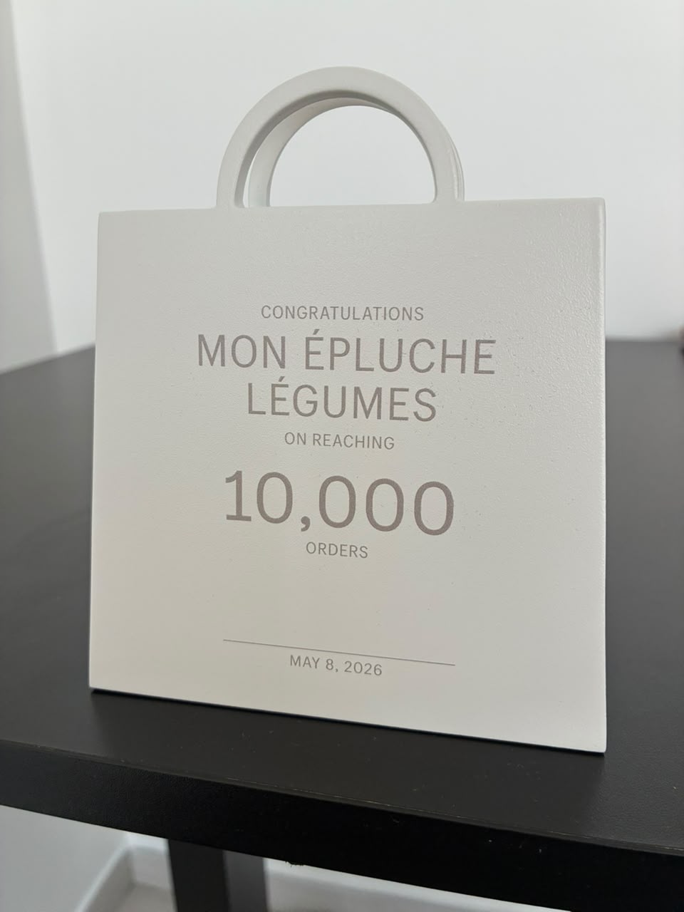 Trophée de Mon Épluche Légumes célébrant le cap des 10 000 commandes, daté du 8 mai 2026